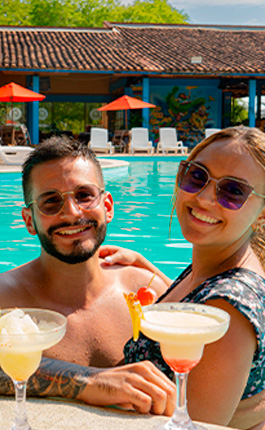 Pareja tomando deliciosos cocteles en la piscina