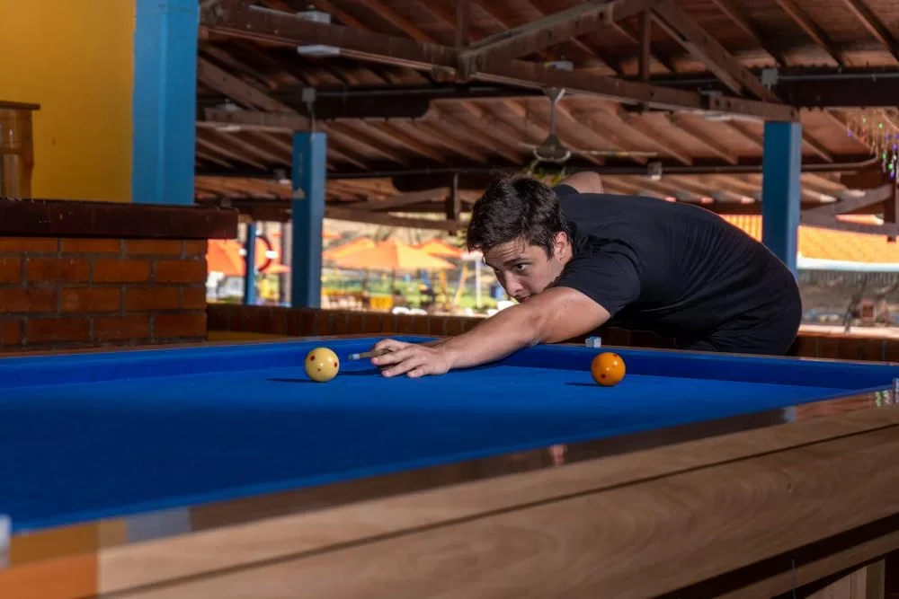 Joven jugando billar en día de sol cerca a Medellín