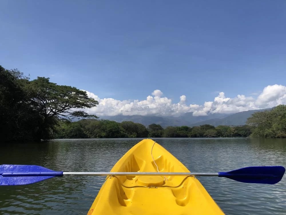 Punta de bote de kayak amarillo en lago grande
